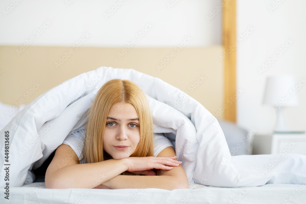 Lazy Sunday. Good morning. Weekend rest. New day. Relaxed calm young pretty woman under blanket in soft clean white bed sheets in cozy light bedroom free space. Lazy Sunday. Good morning. Weekend rest. New day. Relaxed calm young pretty woman under blanket in soft clean white bed sheets in cozy light bedroom free space.
