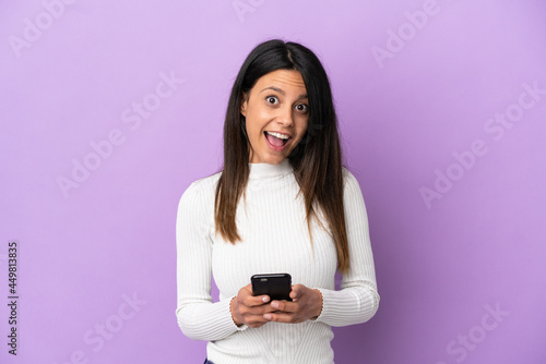 Young caucasian woman isolated on purple background surprised and sending a message