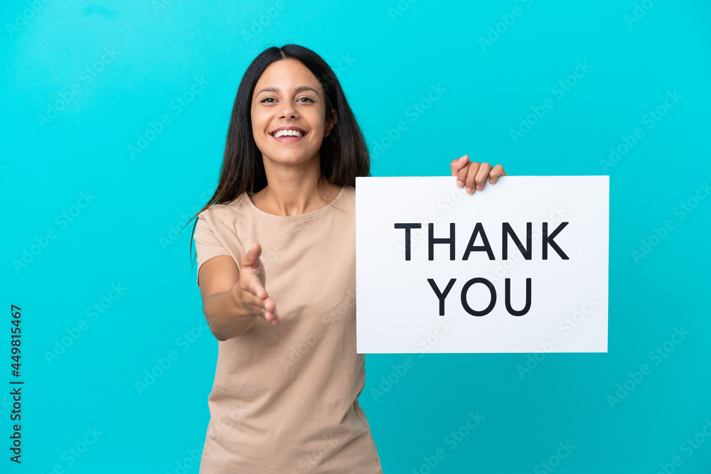 Young woman over isolated background holding a placard with text THANK YOU making a deal Young woman over isolated background holding a placard with text THANK YOU making a deal