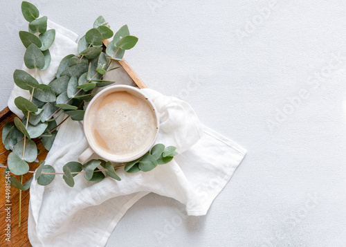 Workspace with leaves eucalyptus, cup of coffee on white background. Art frame. Flat lay, overhead view, home workspace