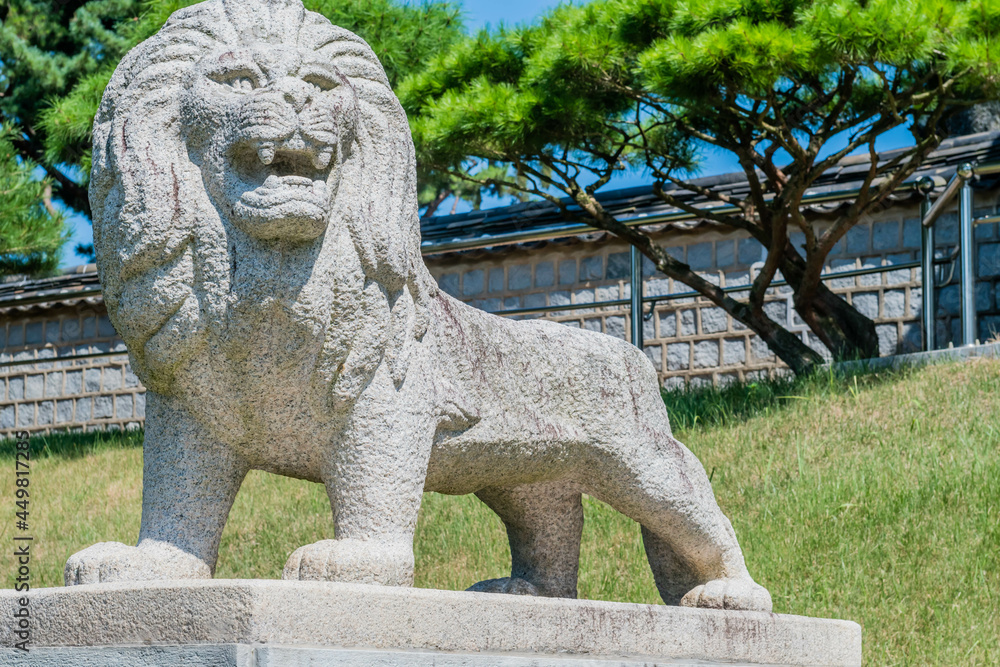 Stone carved lion on concrete plinth at entrance to public park. Stone carved lion on concrete plinth at entrance to public park.