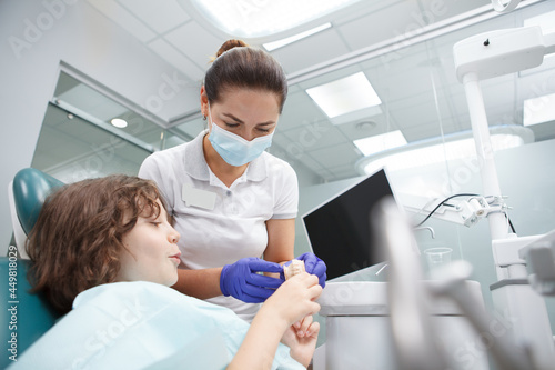 Low angle shot of a female dentist working with child patient, copy space