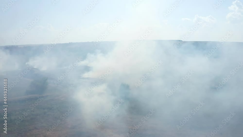 View of the swamps on which peat burns. Natural fire. Gray smoke rises above the dry ground enveloping the plants. The concept of climate change. High quality. 4k footage. View of the swamps on which peat burns. Natural fire. Gray smoke rises above the dry ground enveloping the plants. The concept of climate change. High quality. 4k footage.