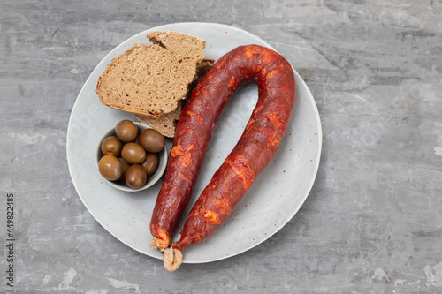 typical portuguese smoked sausage chourico with olives and bread