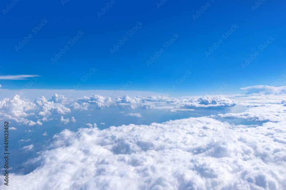 Fototapeta premium Beautiful cumulus fluffy white clouds on a blue sky with bright sun. Perfect abstract sky background, wallpaper
