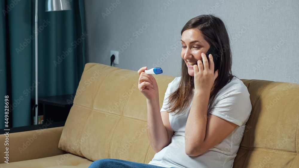 Happy woman talking on the phone holding pregnancy test in hands. Happy woman talking on the phone holding pregnancy test in hands.