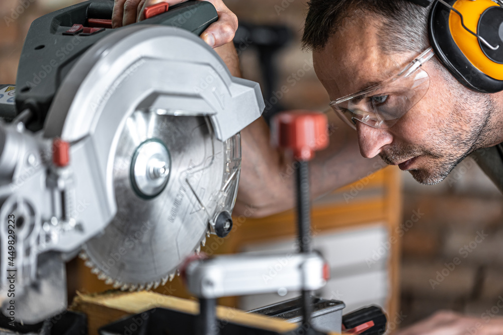 Professional carpenter working with a miter saw.