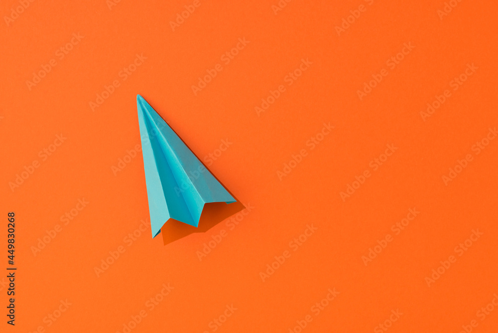 Top view photo of vivid blue paper airplane on isolated orange background with empty space Top view photo of vivid blue paper airplane on isolated orange background with empty space