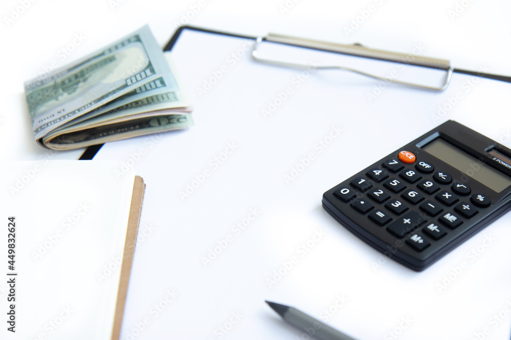 Calculator, paper money and notebook isolated on white background. Concept of debt management, payment of taxes and investing Calculator, paper money and notebook isolated on white background. Concept of debt management, payment of taxes and investing