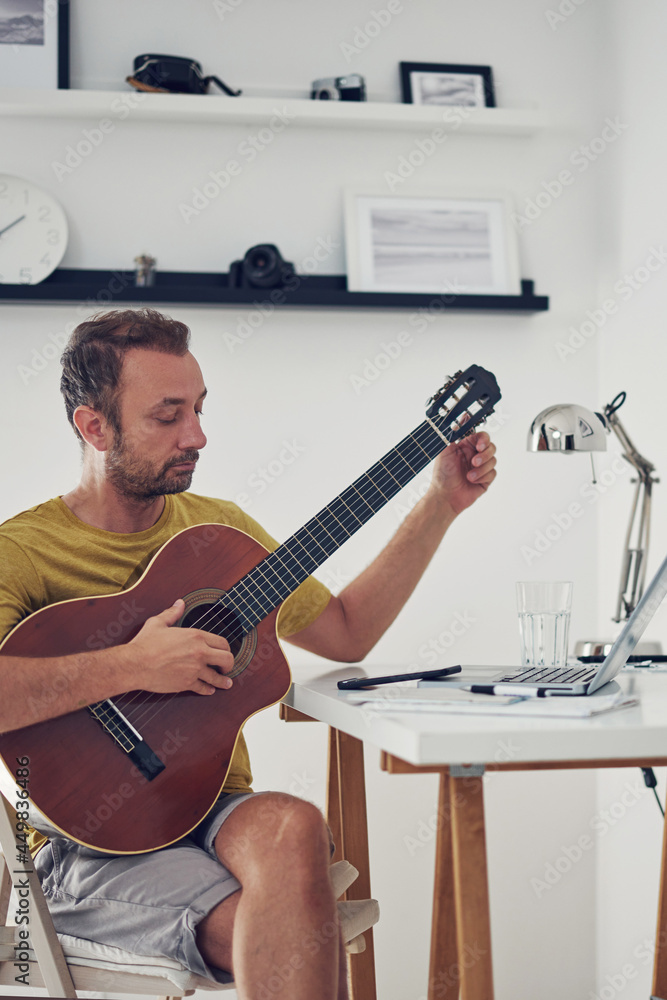 Fototapeta premium Man playing acoustic guitar at home.