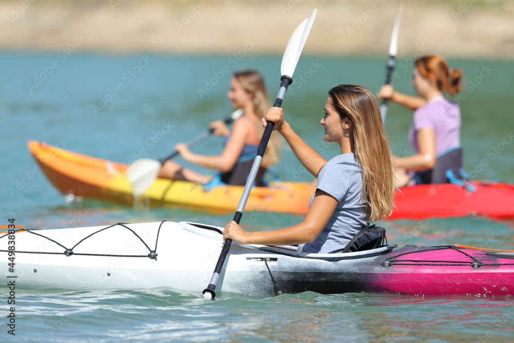Naklejka premium Friends rowing in kayaks in a lake
