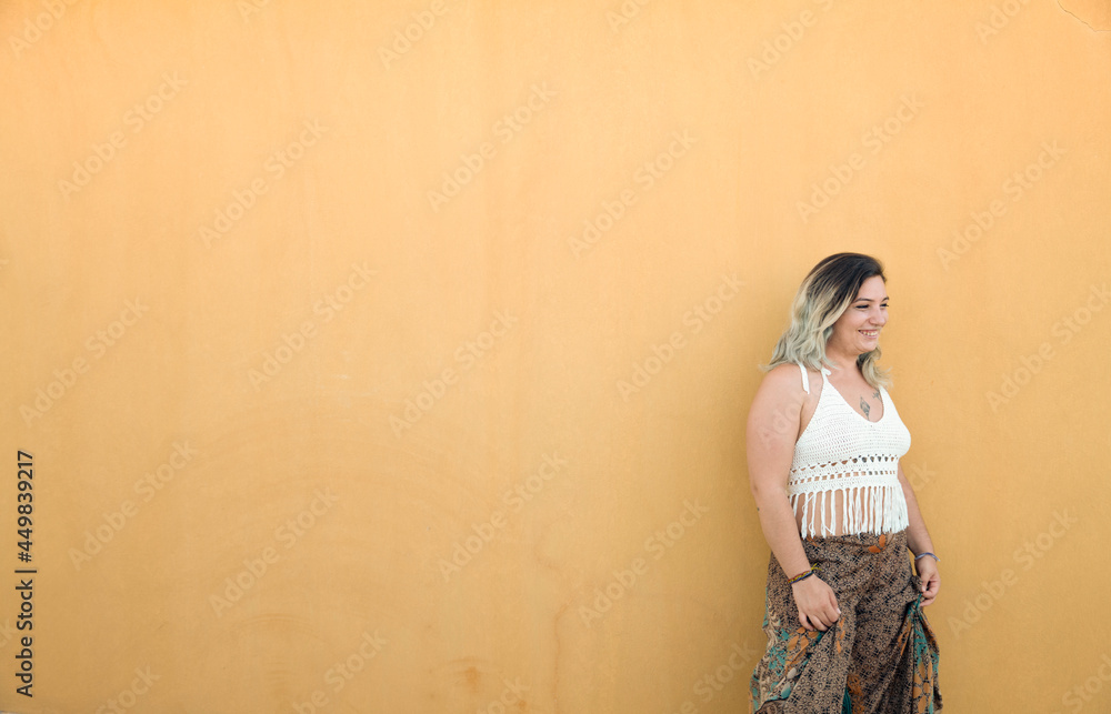 Fototapeta premium Portrait of Happy Spanish girl against yellow wall