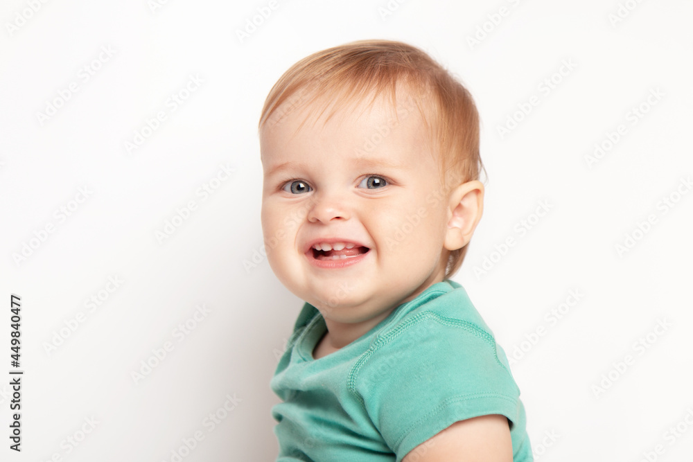 Infant child baby boy in green t-shirt laughs happy looking at the camera isolated on a white background. Childcare and upbringing concept. Infant child baby boy in green t-shirt laughs happy looking at the camera isolated on a white background. Childcare and upbringing concept.