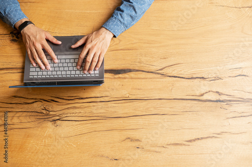 Male hands typing on the keyboard, journalist is writing the article, man chatting online, texting in social networks, sending emails, top view, copy space, bunner photo