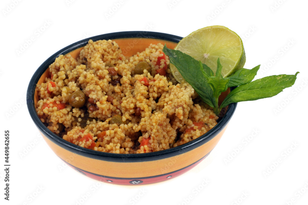 Taboulé au curry avec une rondelle de citron et des feuilles de menthe servi dans un bol en gros plan sur fond blanc Taboulé au curry avec une rondelle de citron et des feuilles de menthe servi dans un bol en gros plan sur fond blanc