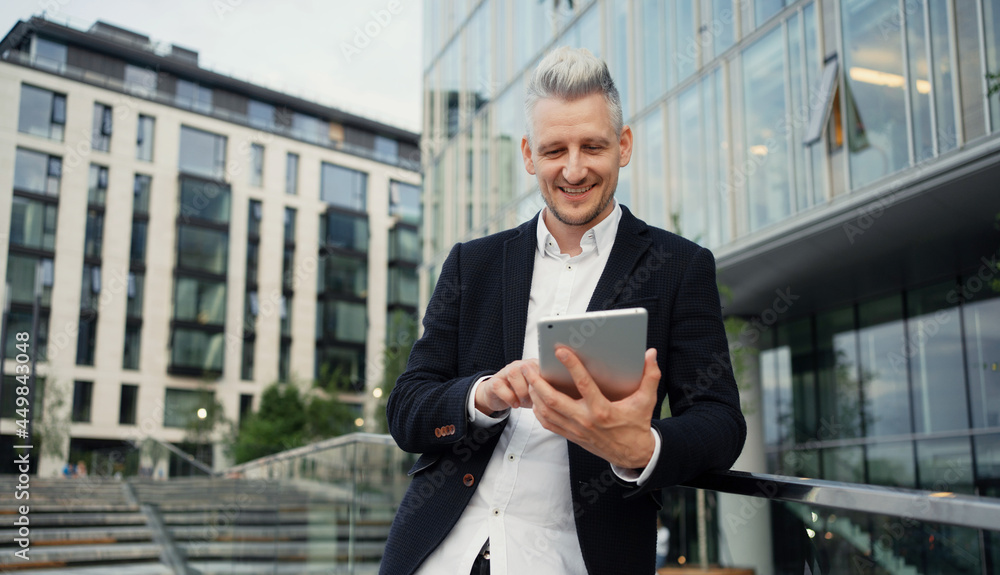 A man of European appearance writes down the task plans in a tablet. A confident freelance manager. An adult gray-haired student does a task online for a new course lesson.