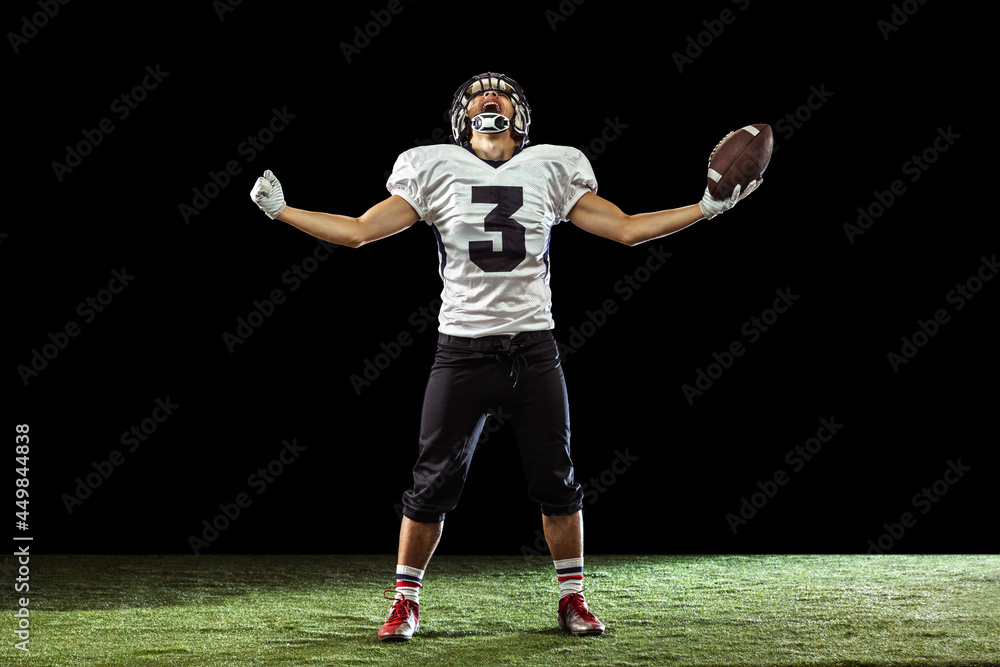 Portrait of American football player equipment helmet and gloves isolated on dark studio background. Concept of sport, competition, goals, medal, win Portrait of American football player equipment helmet and gloves isolated on dark studio background. Concept of sport, competition, goals, medal, win