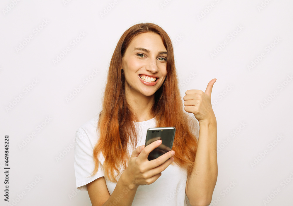 Photo of cheerful beautiful young red-haired woman chatting by mobile phone Photo of cheerful beautiful young red-haired woman chatting by mobile phone