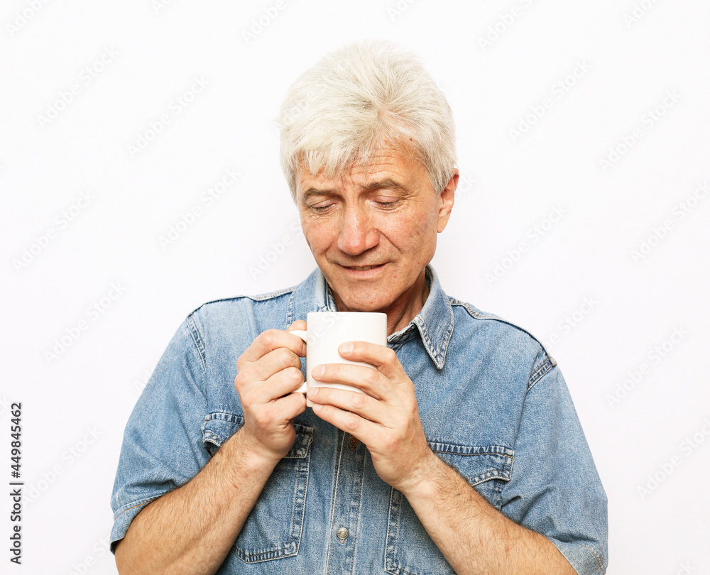 lifestyle, food and people concept: Handsome mature man hoding a cup of coffee or tea