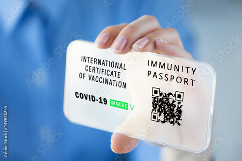 coronavirus, technology and health concept - close up of woman's hand showing transparent smartphone with virtual immunity passport or international certificate of covid-19 vaccination on screen