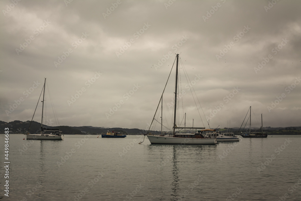 Sepia retro photo of sailing boats waiting out stormy weather in a small harbour