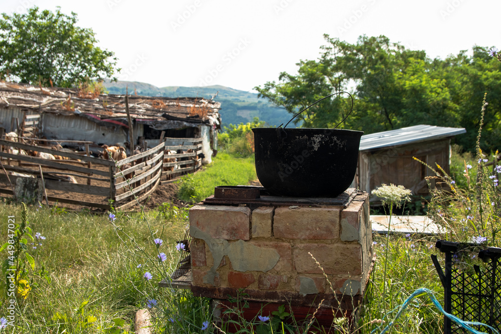 An old cauldron in which milk is prepared at the sheepfold. Sheep sheepfold in Prahova Romania An old cauldron in which milk is prepared at the sheepfold. Sheep sheepfold in Prahova Romania