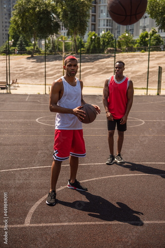 African american sportsmen looking at basketball ball on playground © LIGHTFIELD STUDIOS