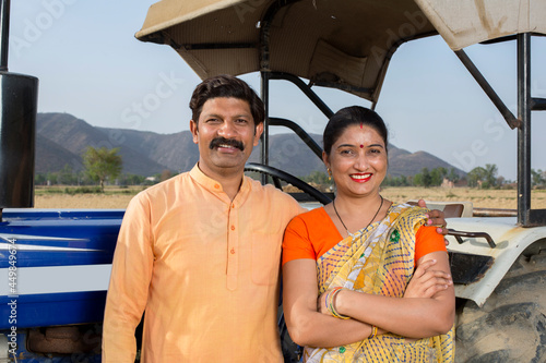 Photography Happy Indian couple with tractor on agriculture field
