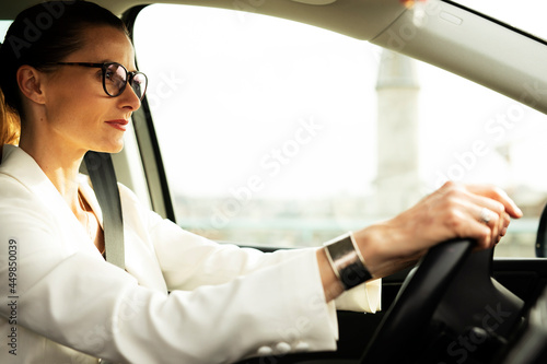 Beautiful businesswoman driving a car. Portrait of smiling woman sitting in the car.