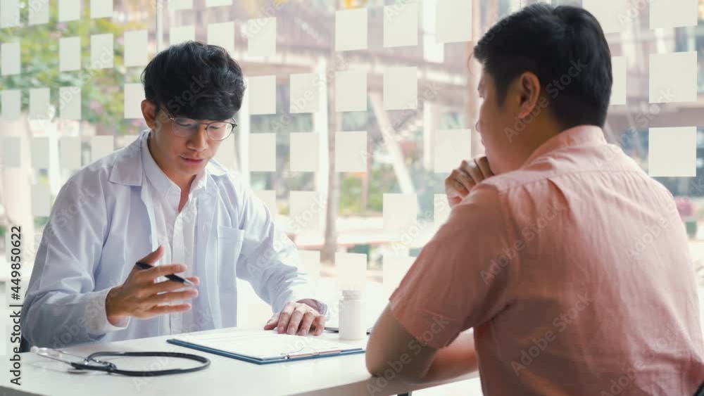 Confident doctor man holding a pill bottle while talking with a senior patient and reviewing his medication at office room. Confident doctor man holding a pill bottle while talking with a senior patient and reviewing his medication at office room.