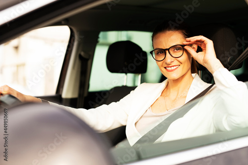 Beautiful businesswoman driving a car. Portrait of smiling woman sitting in the car. © JustLife