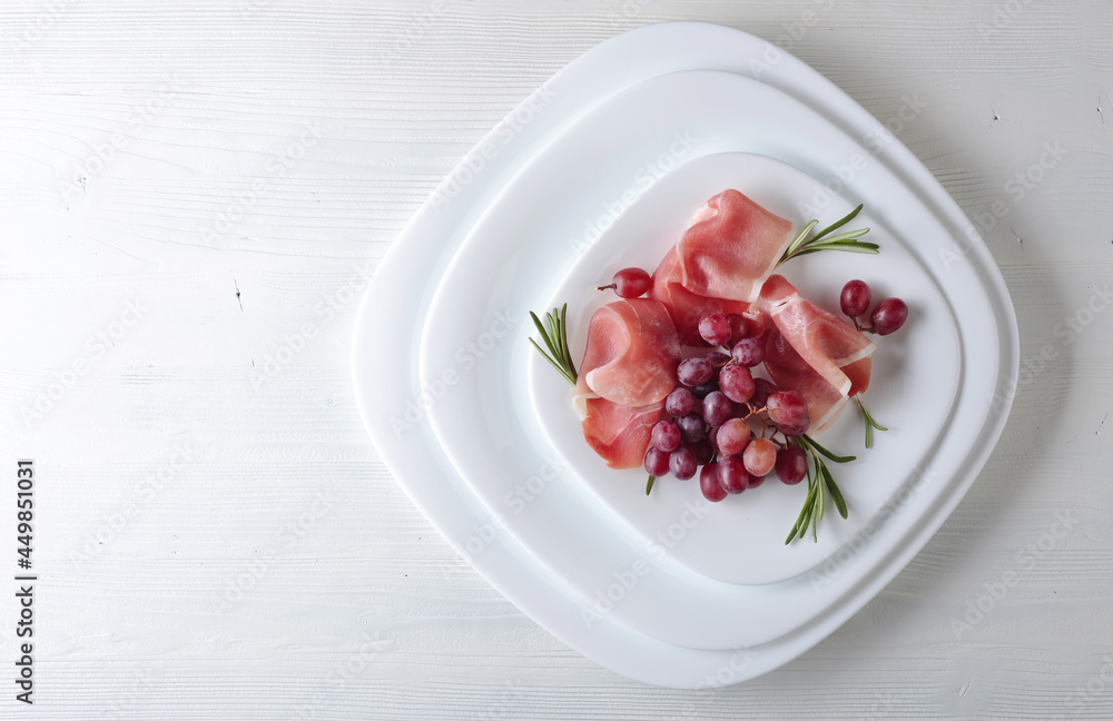 Jamon serrano with rosemary and grape . Jamon serrano with rosemary and grape .