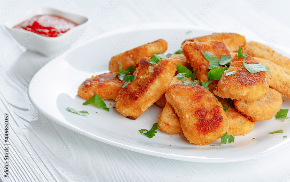 Fried chicken nuggets with ketchup sprinkled with chopped parsley. Fried chicken nuggets with ketchup sprinkled with chopped parsley.