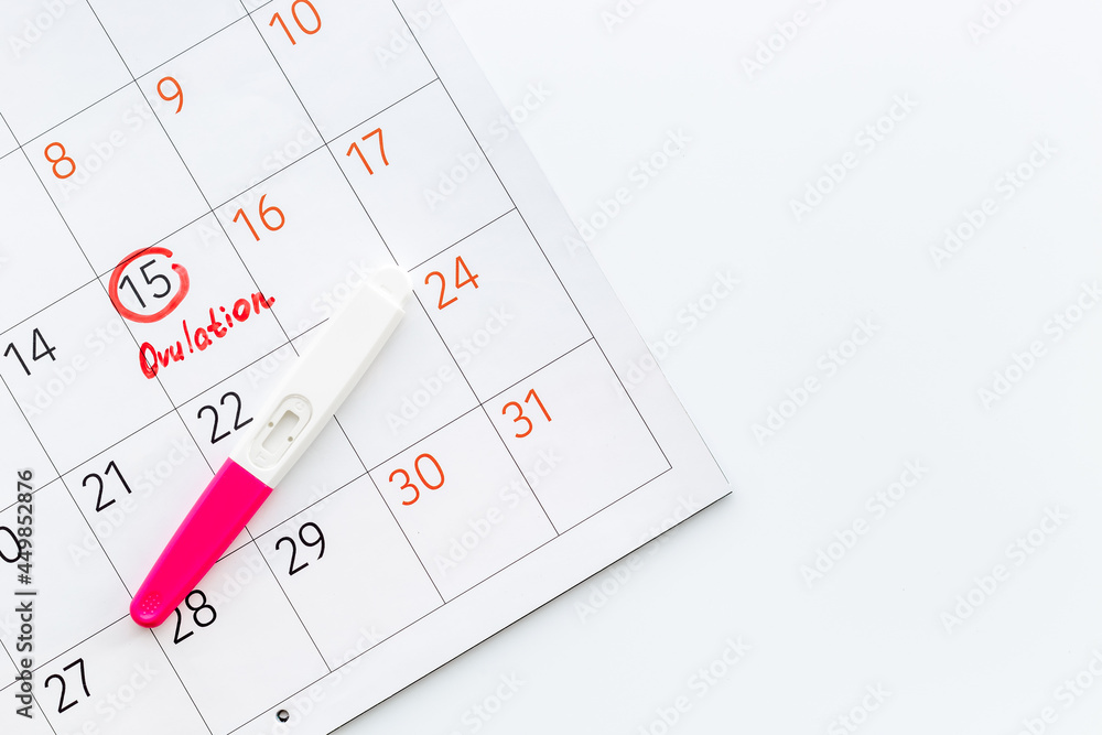 Ovulation home test on calendar with ovulation day red mark Ovulation home test on calendar with ovulation day red mark