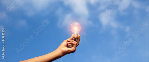 Hand holding light bulb,natural energy and love the world concept.  © bancha