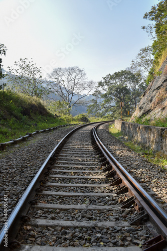 Vertical shot of the train tracks in the forest and mountains captured in Thenmala, Kerala, India photo