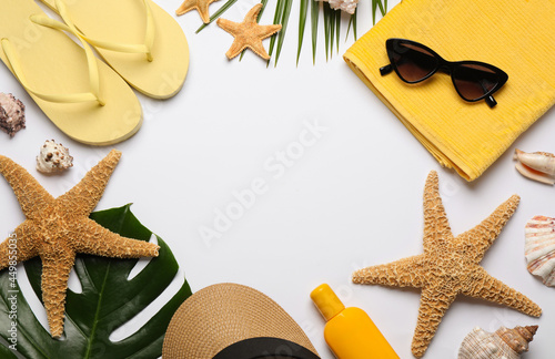 Frame of different beach objects on white background, flat lay. Space for text