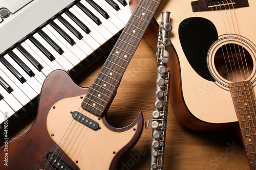 Set of different musical instruments on wooden background, closeup