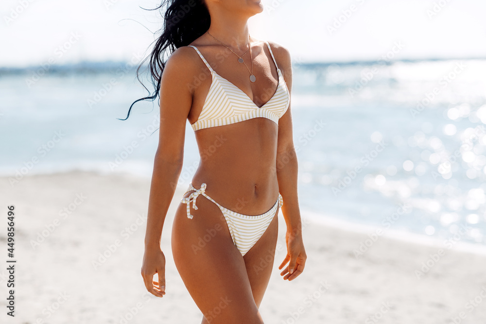 people, summer and swimwear concept - body of young woman in bikini  swimsuit on beach Stock Photo