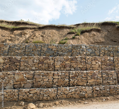 Wire netting gabion boxes on slope to protect the road photo