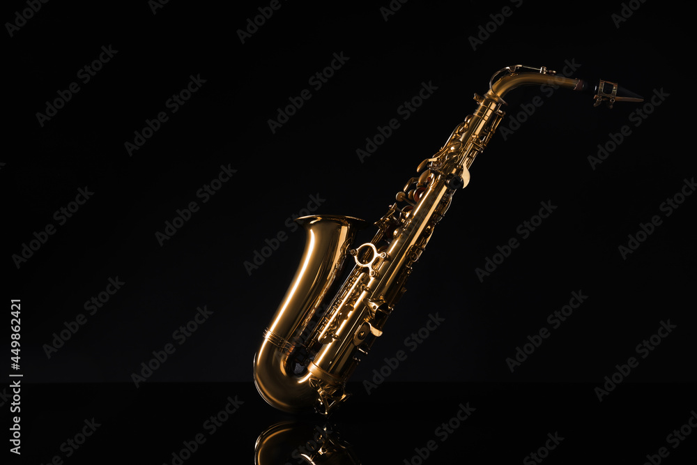 Obraz premium Beautiful saxophone on black background. Musical instrument