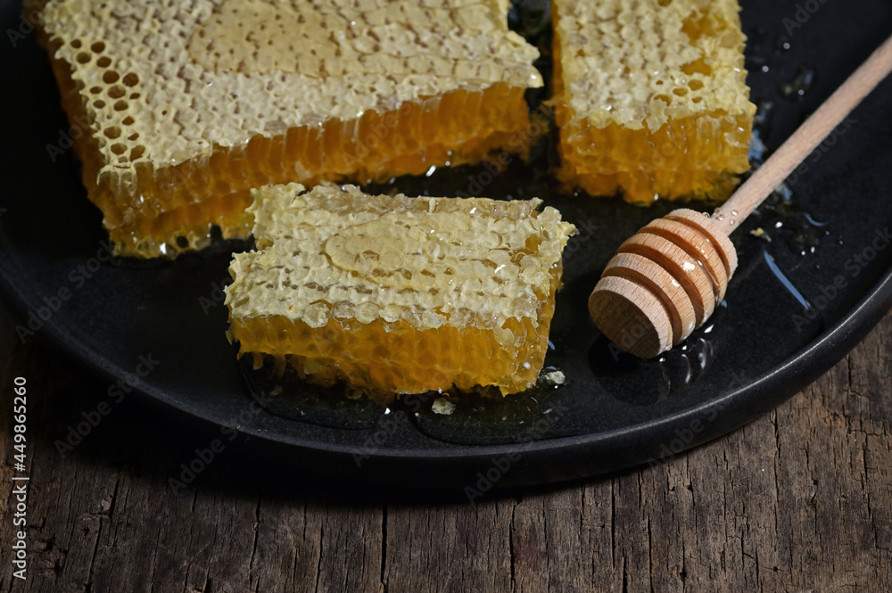Honeycomb and honey dipper on wooden table Honeycomb and honey dipper on wooden table