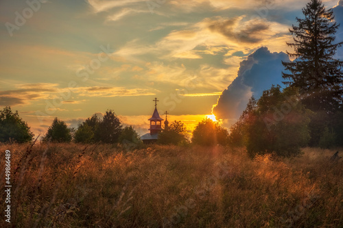 Wooden Chapel of the Kazan Icon of the Mother of God in Olkovo near Andom Mountain at sunset,.Russia, Vologda region, Vytegorsky district photo