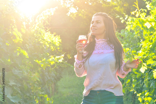 Young beautiful smiling woman walking at wineyard with a glass of red wine.Wine tourism © Striker777