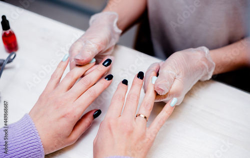 Young woman does a manicure in a nail salon. The process of a specialist's work.