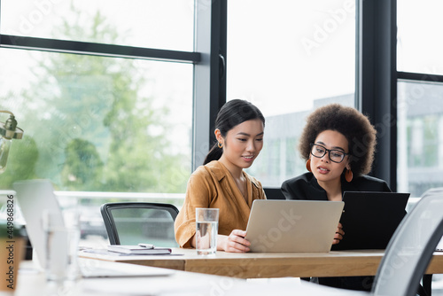 young interracial businesswomen working near laptop in office photo