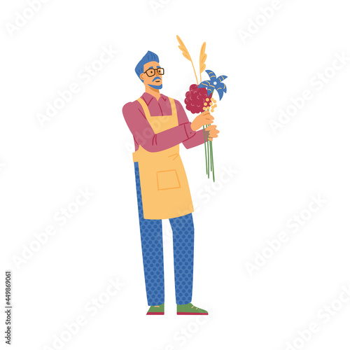 Young male professional florist or seller in flower shop hold beautiful bouquet.