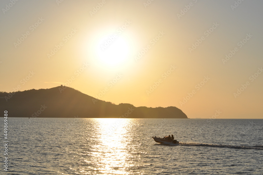 Small boat traveling at high speed on the sea at sunset Small boat traveling at high speed on the sea at sunset
