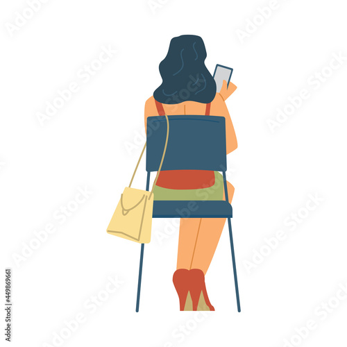 Rear view on back of woman sitting on chair and looking at mobile phone.