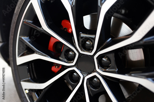 Sports car alloy wheel with red calipers and brakes. Racing brake disc and low profile tyres. Car Shopping and Test Driving. Lower-profile tires are a problem for comfort. High-performance sports cars
